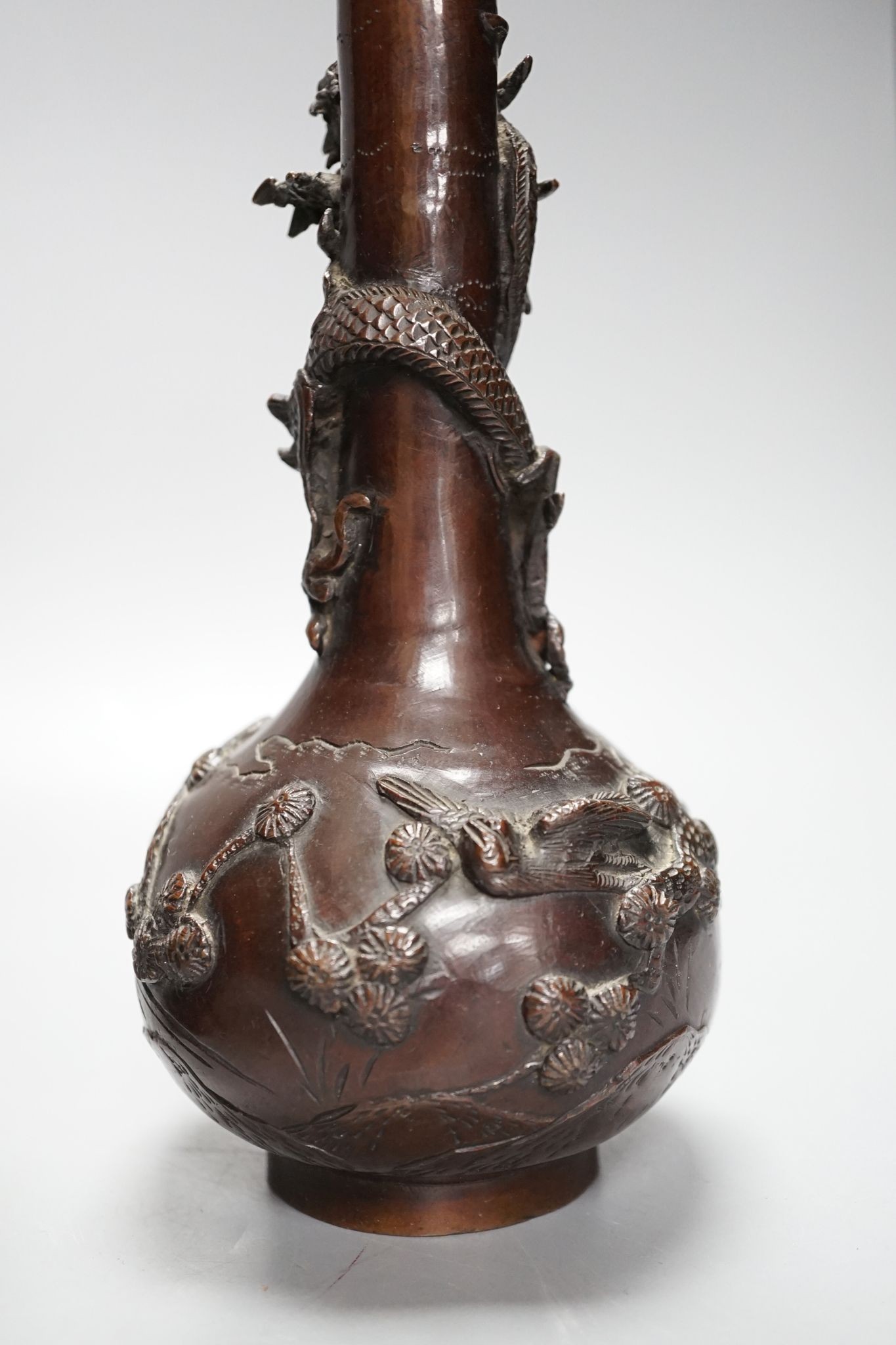 A pair of Japanese Meiji period bronze ‘dragon’ bottle vases and another, 21cm